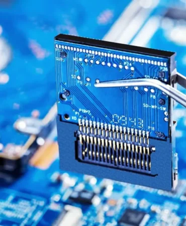 Bir elektronik devre kartı üzerinde cımbızla tutulan bir mikroçip modülünün yakın plan görüntüsü. Görsel, yarı iletken teknolojilerini, çip tasarımı ve test süreçlerini, ayrıca Türkiye'nin mikroelektronik alanındaki yerli üretim kapasitesini geliştirme, teknolojik dışa bağımlılığı azaltma ve küresel yarı iletken değer zincirinde daha güçlü bir konum elde etme hedeflerini simgelemektedir.