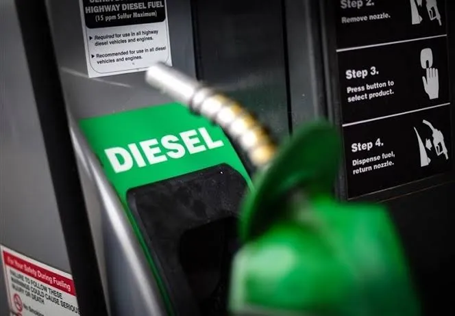 Bir akaryakıt istasyonunda, üzerinde beyaz “DIESEL” yazısı bulunan yeşil motorin pompasının yakın plan görüntüsü.