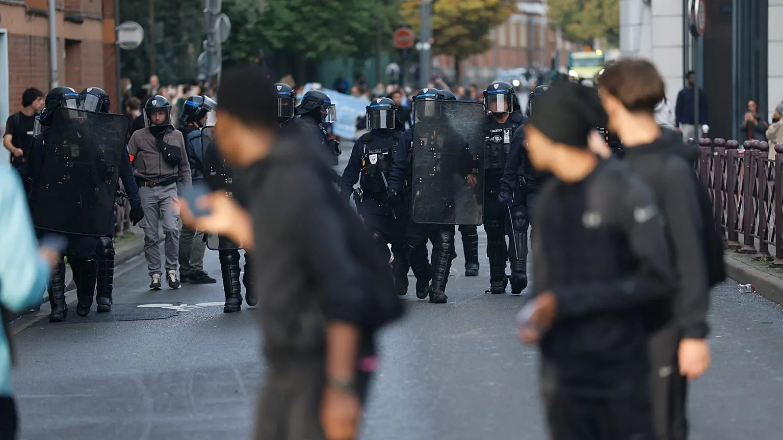 Bordeaux’da pankartlar taşıyan lise öğrencileri ve okul girişinde konuşlanan çevik kuvvet ekipleri.