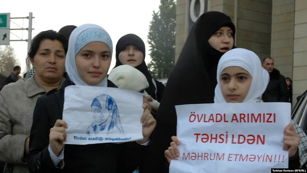 Azerbaycan'da başörtülü kız öğrenciler, okullardaki başörtüsü kısıtlamalarını “Çocuklarımızı eğitimden mahrum etmeyin” ve “Vicdan özgürlüğü kutsaldır” yazılı pankartlarla protesto ediyor. Fotoğraf, 2010 yılındaki protestolara aittir.