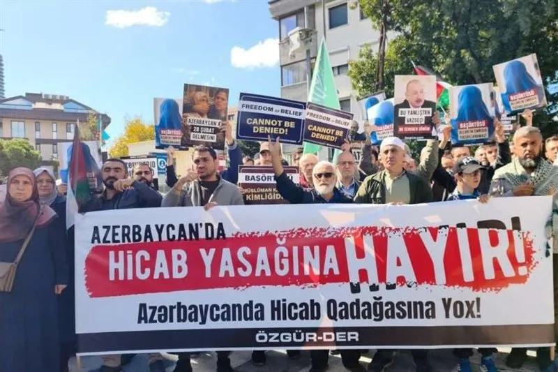 Türkiye'de Azerbaycan'daki başörtüsü yasağına karşı düzenlenen protesto gösterisi. Katılımcılar, İlham Aliyev'in fotoğraflarını ve “Azerbaycan'da başörtüsü yasağına hayır!” yazılı pankartları taşıyarak dinî kıyafetlere yönelik kısıtlamaların kaldırılmasını talep ediyor.