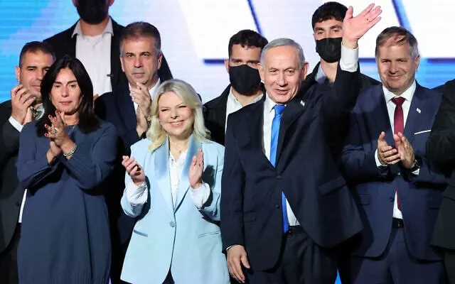 Likud toplantısında, eşi Sara ve alkışlayan katılımcıların yanında sahneden el sallayan Binyamin Netanyahu.